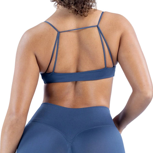 Person wearing a blue sports bra and leggings on a light blue background
