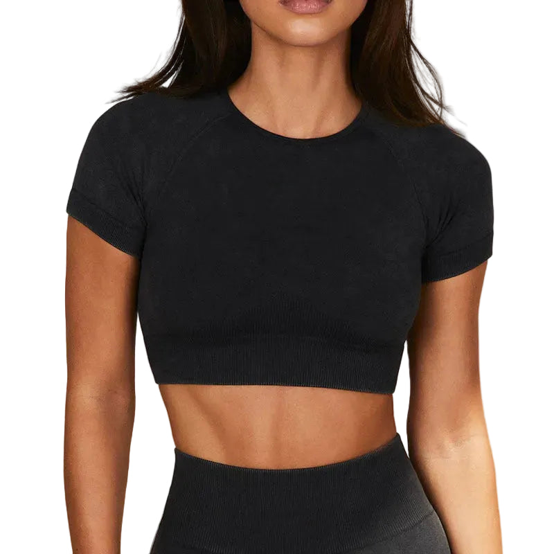 Person wearing a black crop top and leggings against a neutral background
