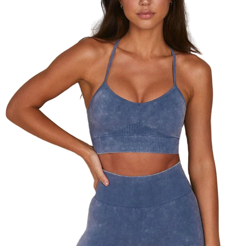 Woman wearing a blue sports bra and leggings against a neutral background