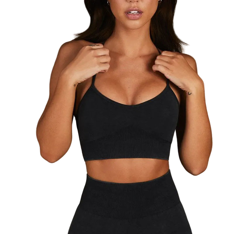 Woman wearing a black sports bra and leggings against a neutral background